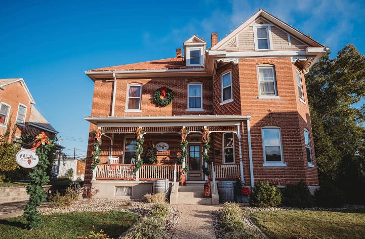 A decorated brick house adorned with holiday wreaths and garlands.